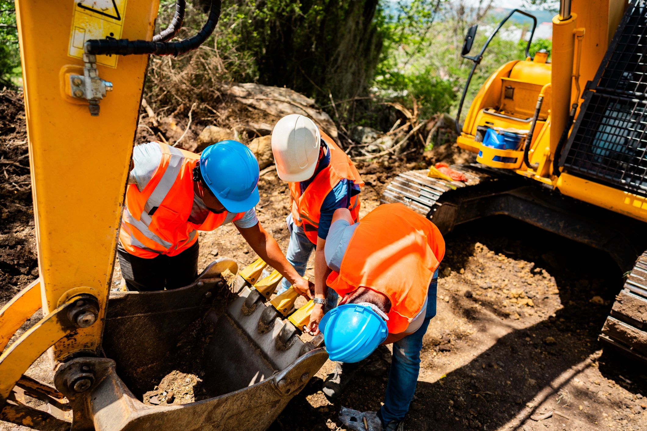 Construction workers inspecting equipment at a job site
