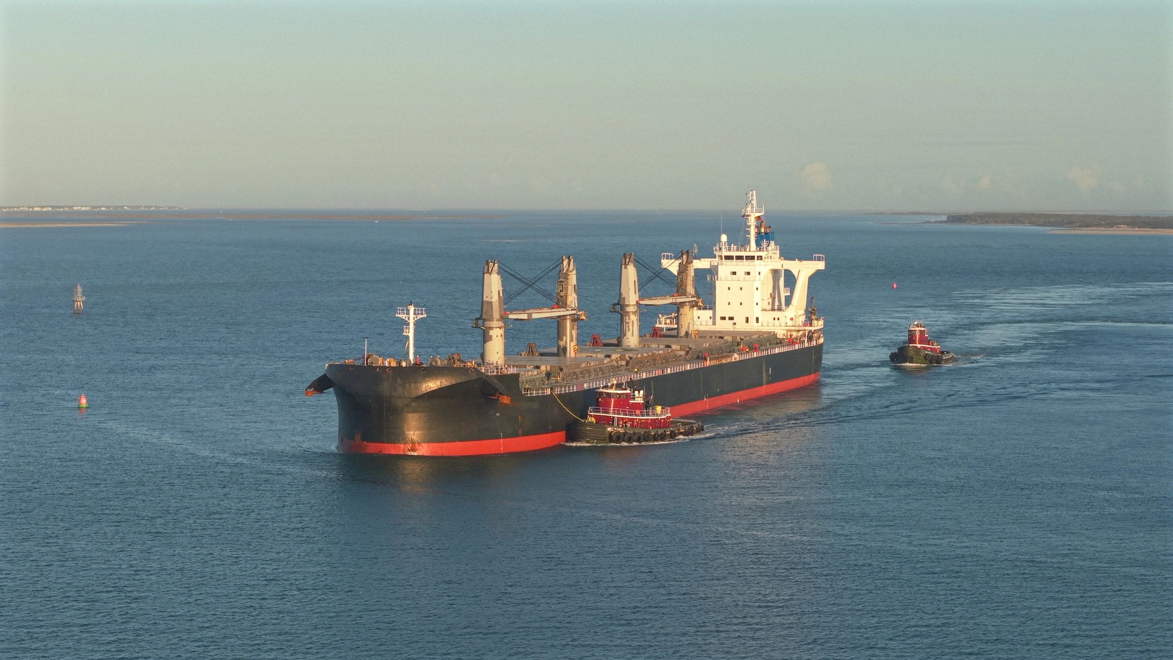 Cargo ship at sea with tug boat